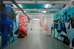 Contemporary installation in W139, featuring a 30 meter long mural for the Summer Jam exhibition (2018). Walking through the tunnel, you feel that the geometrical shapes in different shades of vibrant blues, black and white, suggest movement.