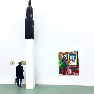 Contemporary art gallery installation in W139, called Studio Double V. Featuring a large abstract sculpture by Landzbergas, next to the vibrant painting Boijmans by Axel Linderholm on a white wall.