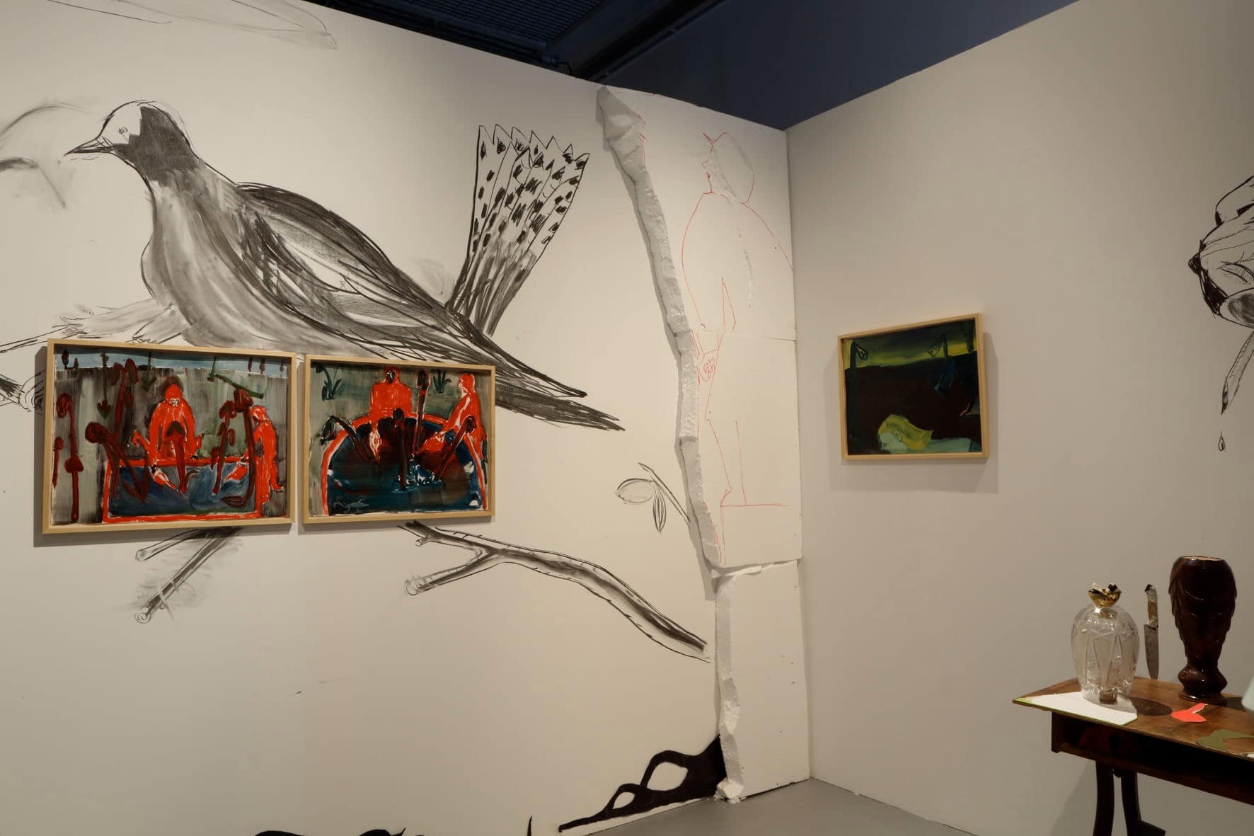 Art installation with dark atmospheric paintings, drawings of birds and sculptures of utensils in the Centre for Contemporary Art Vilnius.